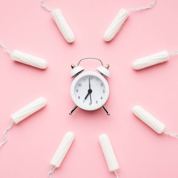 alarm clock surrounded by tampons. High resolution photo - Photo, Image