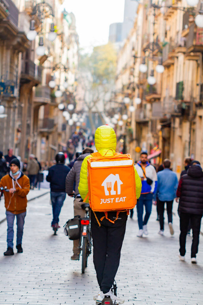 Barcelona, Spain - April 4, 2022: fast food delivery ( just eat) with scooter in the gothic quarter of Barcelona (Spain), selective approach- - Foto, afbeelding