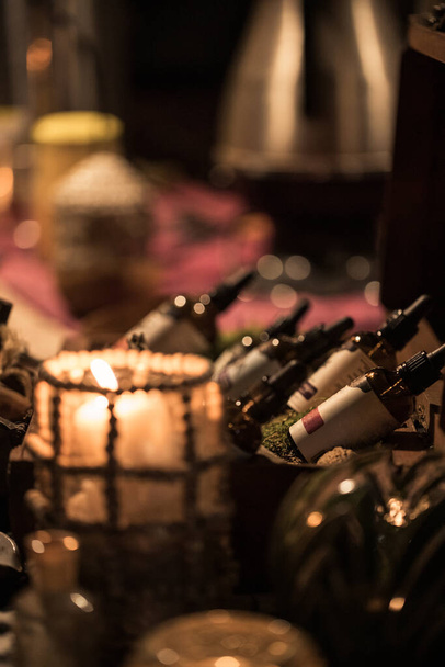 The medicine dropper bottles on blurred dark background, candles, and decorations - Fotoğraf, Görsel