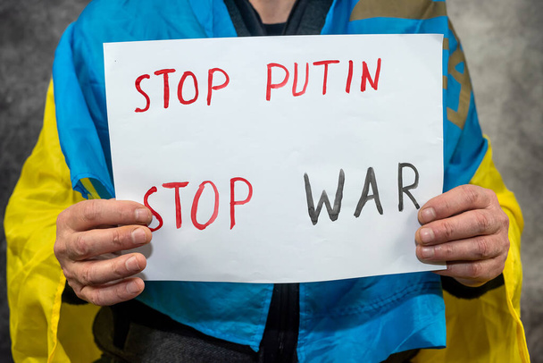 manos masculinas sosteniendo pancarta con la inscripción stop putin. Rusia al agresor y al teórico internacional  - Foto, imagen