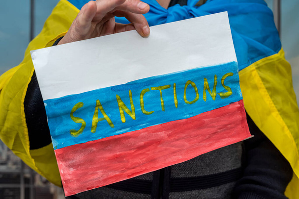 poster in male hands with text sanction for Russia. complete isolation for the terrorist state - Photo, Image