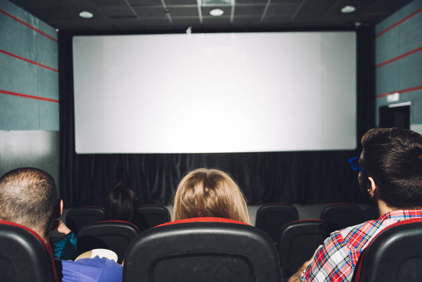 Люди смотрят на экран кинотеатра сзади. Фото высокого разрешения - Фото, изображение