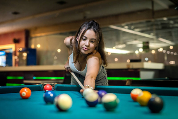 pretty lady take to easy shoot to win in billiards game. pleasantly spent free time - Φωτογραφία, εικόνα