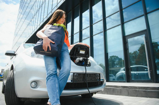 Woman is charging rental electric car. - Fotó, kép