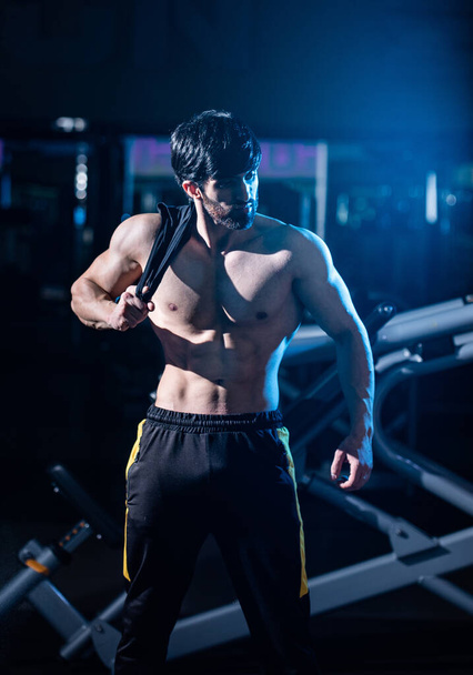 A vertical shot of a fit athletic muscular Caucasian man posing at the gym - 写真・画像