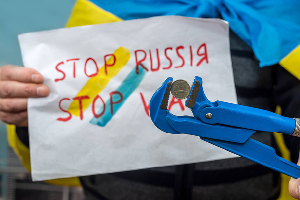 Egy ukrán férfi Ukrajna szimbólumaiba csomagolva emléktáblákat tart az Ukrajnával vívott háború oldalán feliratokkal. Az orosz háború koncepciója Ukrajnával. Az ukránok elleni erőszak - Fotó, kép