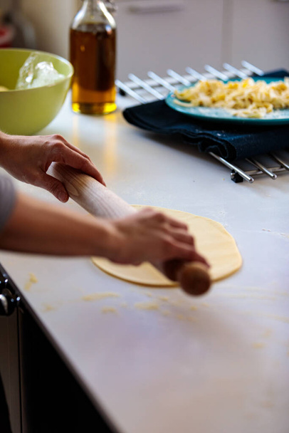 A vertical shot of a person using a rolling pin for dough - Foto, imagen