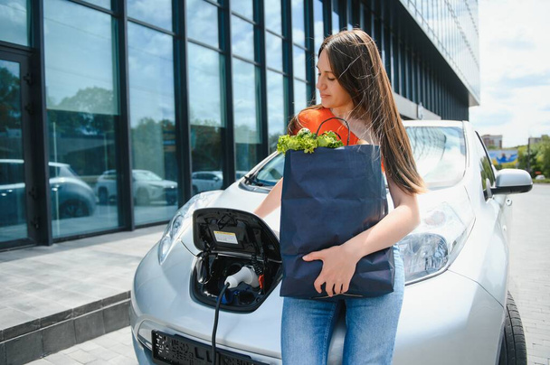 Woman is charging rental electric car. - Fotoğraf, Görsel