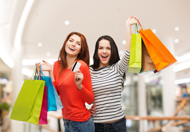 two smiling teenage girls with shopping bags - Photo, Image