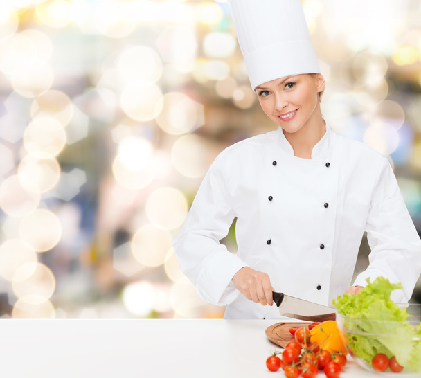 smiling female chef chopping vegetables - Fotó, kép