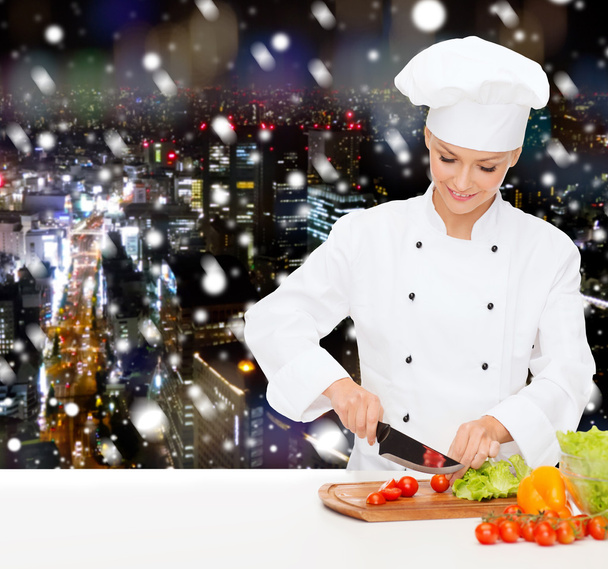 smiling female chef chopping vegetables - Zdjęcie, obraz