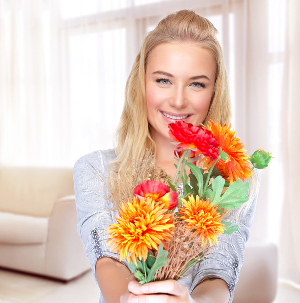 Mujer feliz con flores en casa
 - Foto, imagen