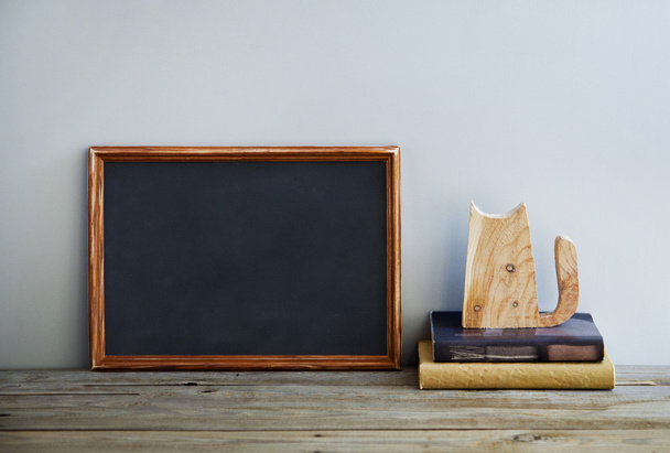 chalkboard frame on the grey wall with books and cat - Φωτογραφία, εικόνα