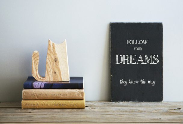 Φράση παρακίνησης ακολουθήστε τα όνειρά σας στο μαυροπίνακα με βιβλία - Φωτογραφία, εικόνα