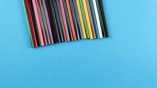 A bunch of color pencil on a blue background. Selective focus on the pencil color   - Фото, зображення