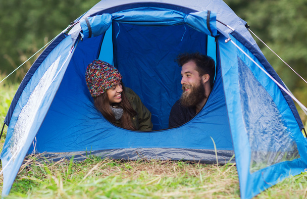 smiling couple of tourists looking out from tent - Foto, Imagem