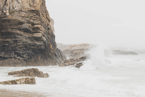 The waves crashing against rocks on a rainy day. Punta Corveira, Lugo, Galicia, Spain. - Фото, зображення