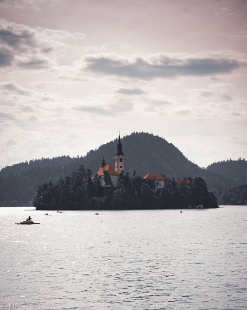 The Assumption of Maria Church on island on lake Bled in Slovenia on cloudy sky background - Photo, Image