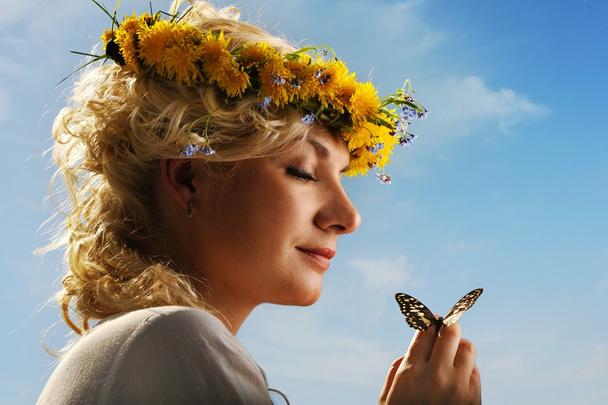 όμορφη γυναίκα με μια πεταλούδα πάνω από το γαλάζιο του ουρανού - Φωτογραφία, εικόνα