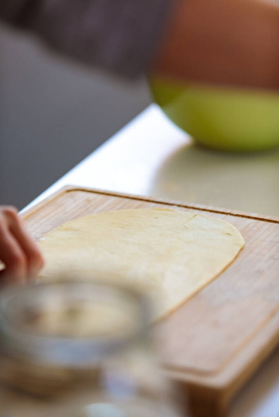 A vertical selective-focus shot of a dough on a cutting board - Photo, Image