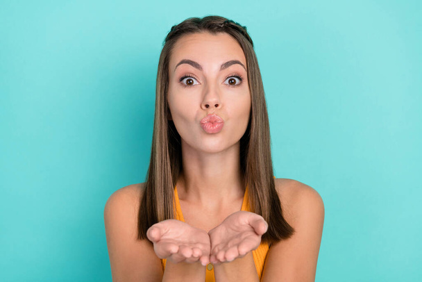 Photo of charming flirty happy young woman send air kiss you hands lips pouted isolated on teal color background. - Foto, immagini