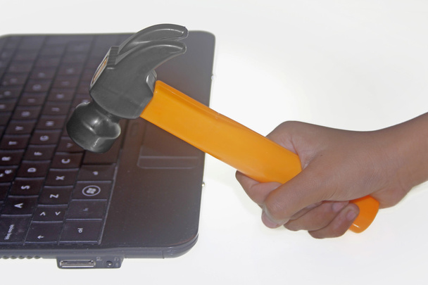 Hammer in Human Hand lyömällä kannettava tietokone
 - Valokuva, kuva