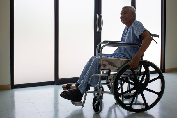 Senior man Patients sitting on wheelchairs. Patients man sitting in modern wheelchair indoors - Фото, изображение