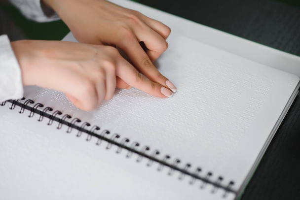 Blind woman read book written in Braille. Close up finger touch to braille Code. - Foto, Imagen