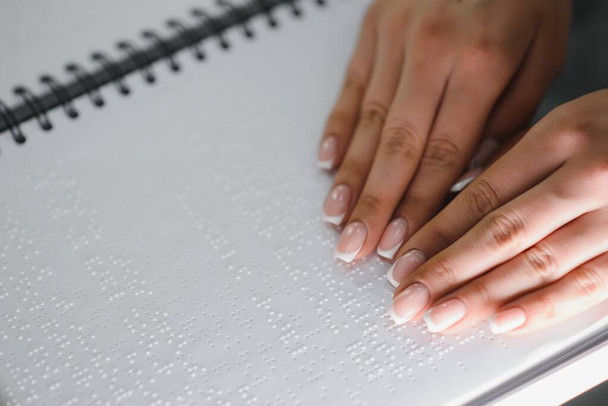 Blind woman read book written in Braille. Close up finger touch to braille Code. - Fotó, kép