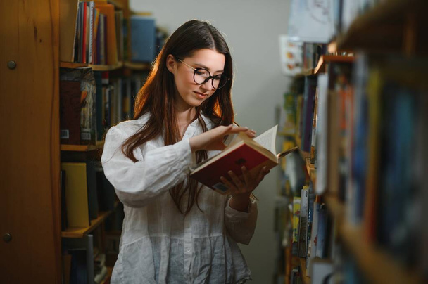 Portrait of a student girl studying at library. - Φωτογραφία, εικόνα
