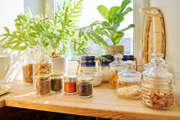 Storage of food in the kitchen in pantry. Glass jars with different spices, nuts, dry fruits. Cooking at home, stocking food - Foto, immagini