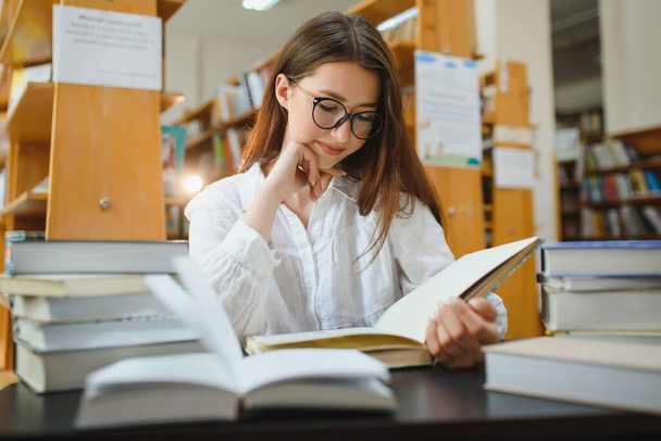 Portrait of a student girl studying at library. - Foto, immagini