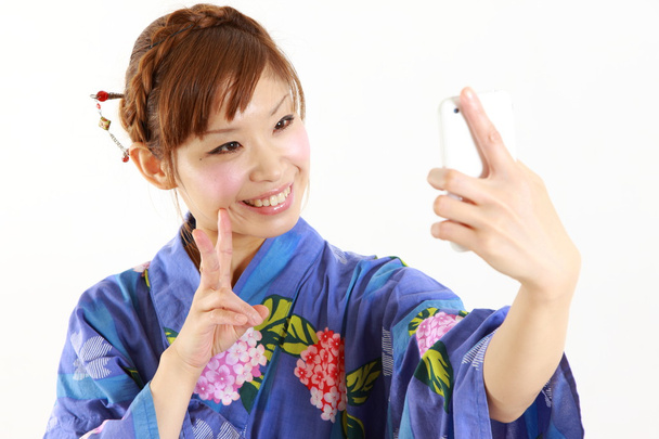 Japanese woman wearing KIMONO takes a selfie - Photo, image