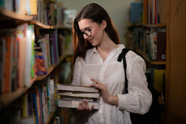 Portrait of a student girl studying at library. - Фото, зображення