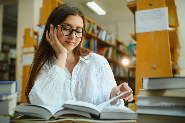 Education, high school, university, learning and people concept. Smiling student girl reading book. - Fotografie, Obrázek