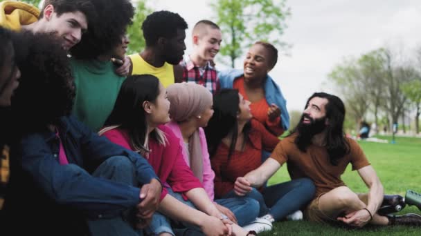 公園で一緒に楽しむ若い多人種の友人のグループ-友情と多様性の概念 - 映像、動画