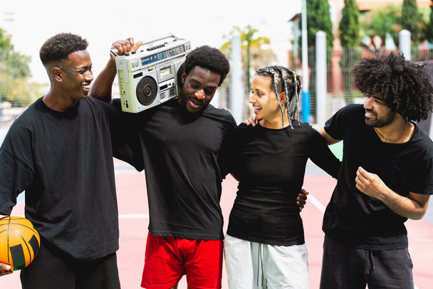 Jóvenes afroamericanos se divierten escuchando música con boombox vintage al aire libre - Vida urbana de la gente de la calle - Foto, Imagen