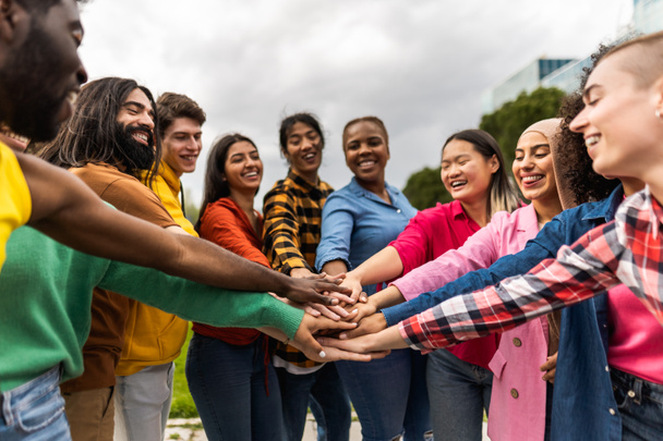 Jeune communauté multiraciale d'amis s'amusant empiler les mains ensemble en plein air - concept d'amitié et de diversité - Photo, image