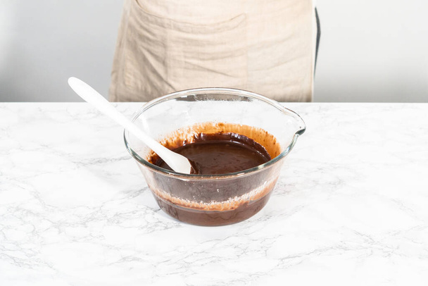 Preparing chocolate ganache in a glass mixing bowl. - Foto, Imagem