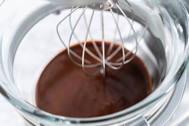 Zweep chocolade ganache met een elektrische keukenmixer. - Foto, afbeelding