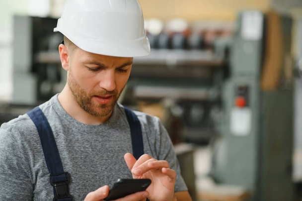 Management team, engineer, or foreman. Standing checking job information about industrial production management within the factory by phone. Teamwork concept. - Fotó, kép