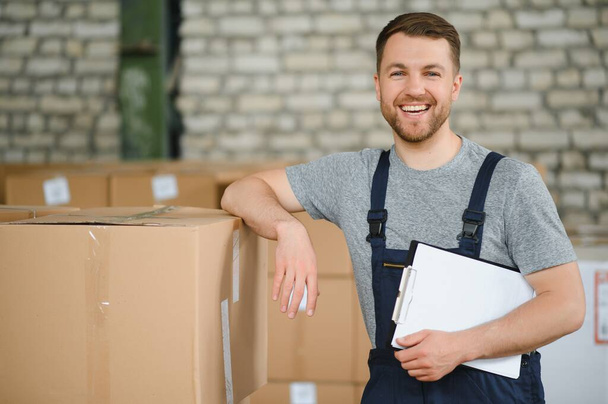 Warehouse worker carrying a carton for delivery to production stock - Photo, image