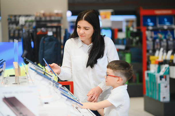woman with son in store buying new phone - Foto, Imagem