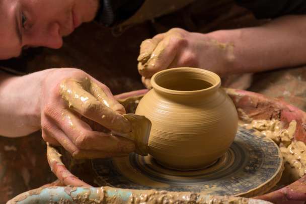hands of a potter, creating an earthen jar - Фото, изображение