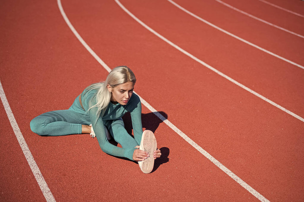 sport and fitness. healthy lifestyle. workout on outdoor stadium. physical training. athletic lady has flexible body. stretching. energetic woman warming up. sporty girl in sportswear warm up. - Fotoğraf, Görsel