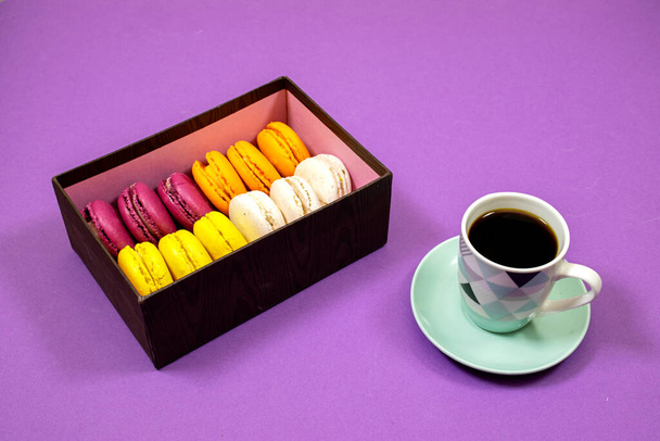 Francouzské barevné Macarons Cookies a šálek kávy na fialovém pozadí - Fotografie, Obrázek