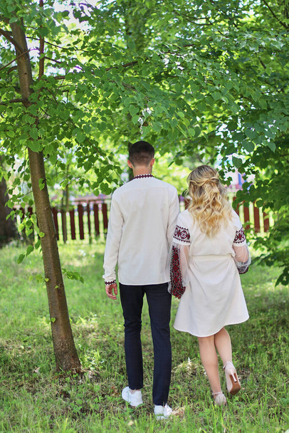 Young couple walking in the garden on a sunny summer day. - Foto, afbeelding