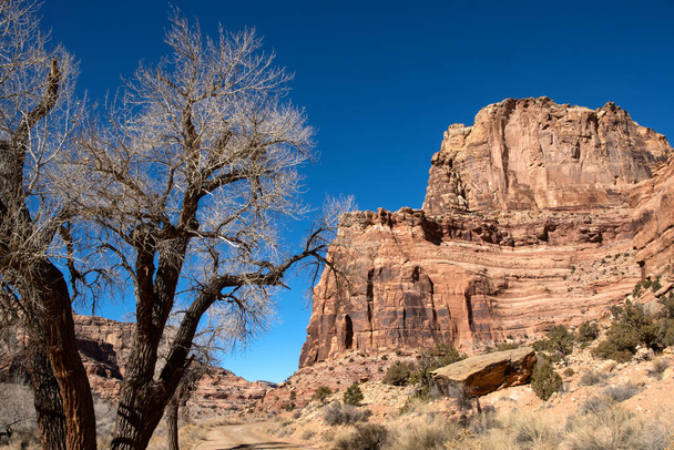 Egy földút felfedezése vörös sziklaformációkkal Moab Utah közelében. - Fotó, kép