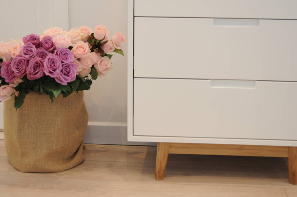 A pink roses bouquet on a wooden floor indoors - Photo, image