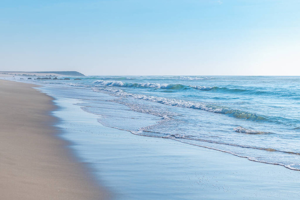Piękna plaża Praia Da Barra i Costa Nova, słynne wypady Aveiro, Portugalia. Ocean Atlantycki z pięknymi błękitnymi wodami i czystym niebem - Zdjęcie, obraz